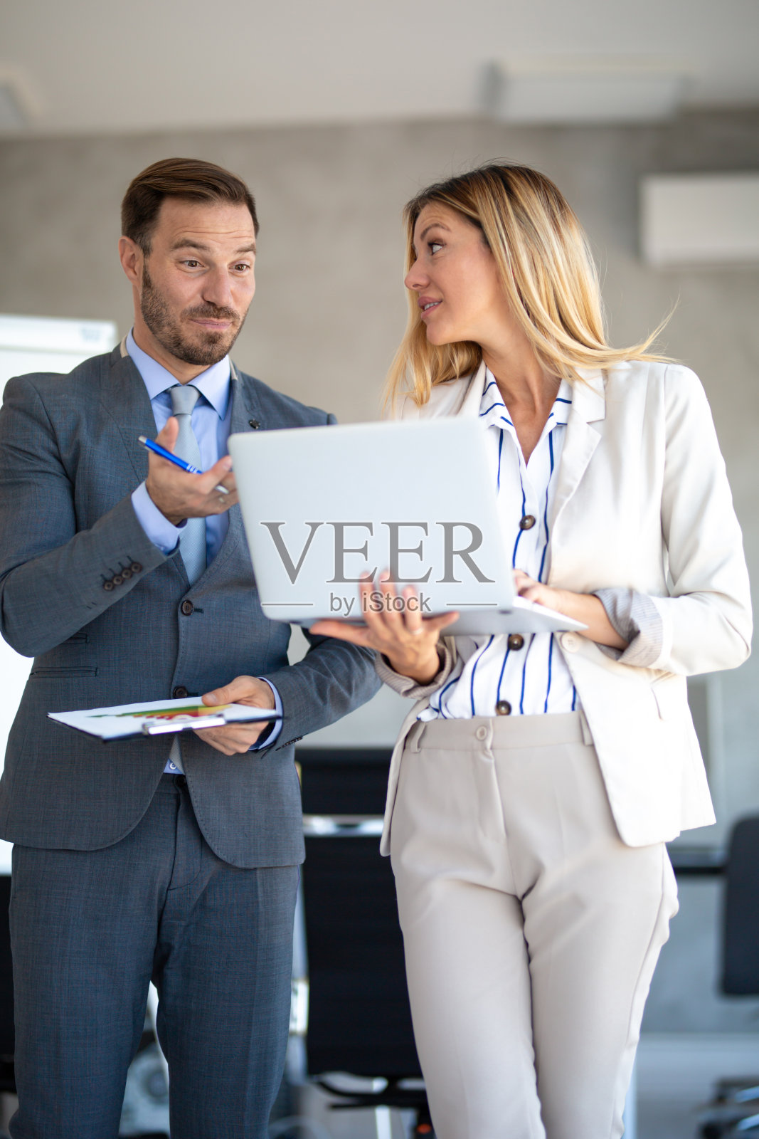 一对愉快的成功的商业人士在明亮的现代办公室开会照片摄影图片