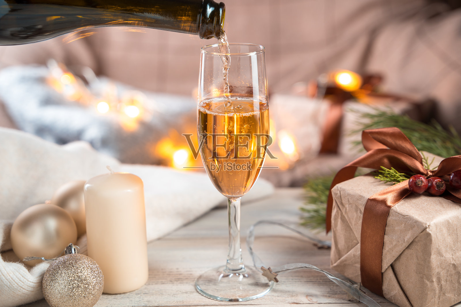 圣诞背景与一个瓶子装满一杯香槟在一个灯光背景。照片摄影图片