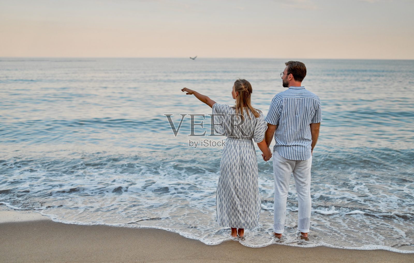 海滩上的一对情侣。照片摄影图片