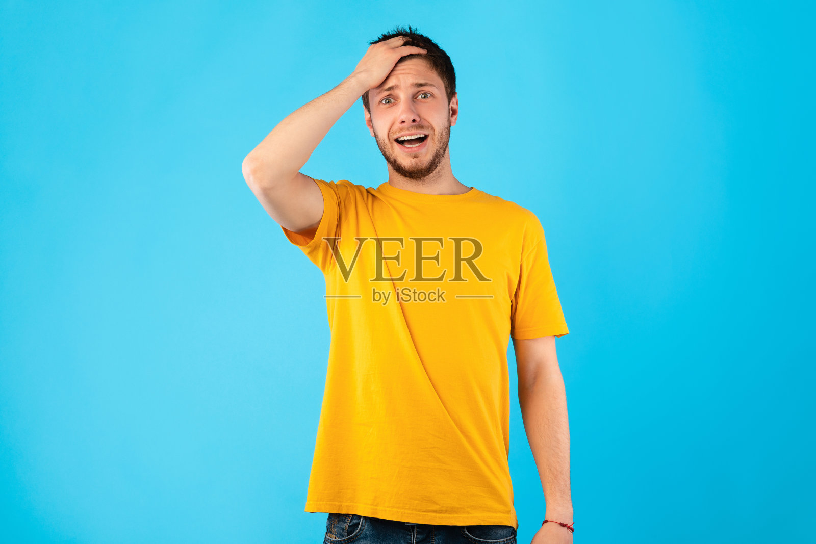 震惊的家伙张着嘴，手放在头上照片摄影图片