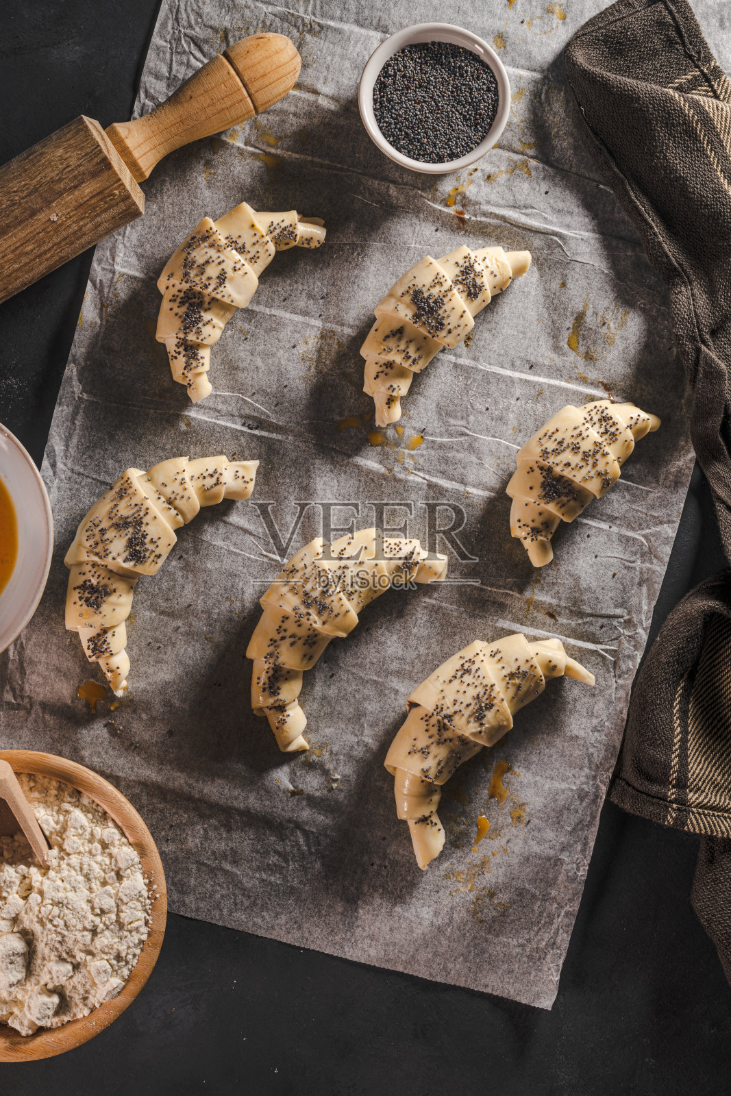 在家里或咖啡馆制作经典的小牛角面包。法国糕点产品。家庭烹饪的概念。准备烤牛角面包照片摄影图片