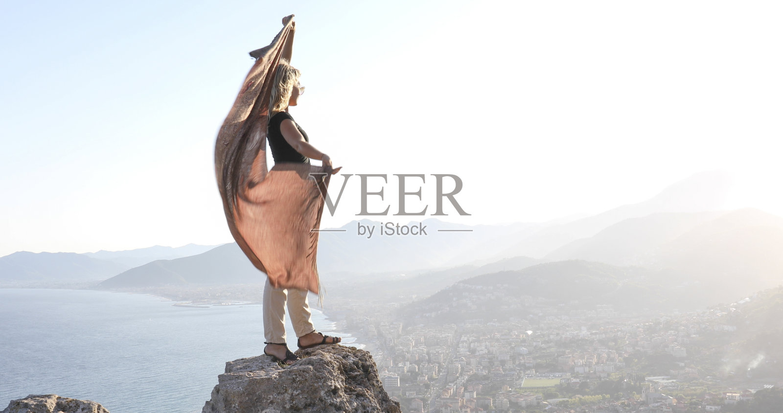 年轻女子清晨在海边的悬崖上跳舞照片摄影图片