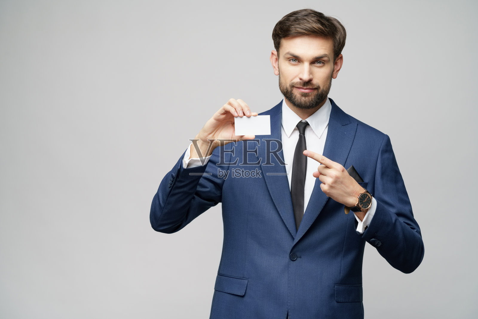 年轻英俊的商人，持有商业或信用卡照片摄影图片