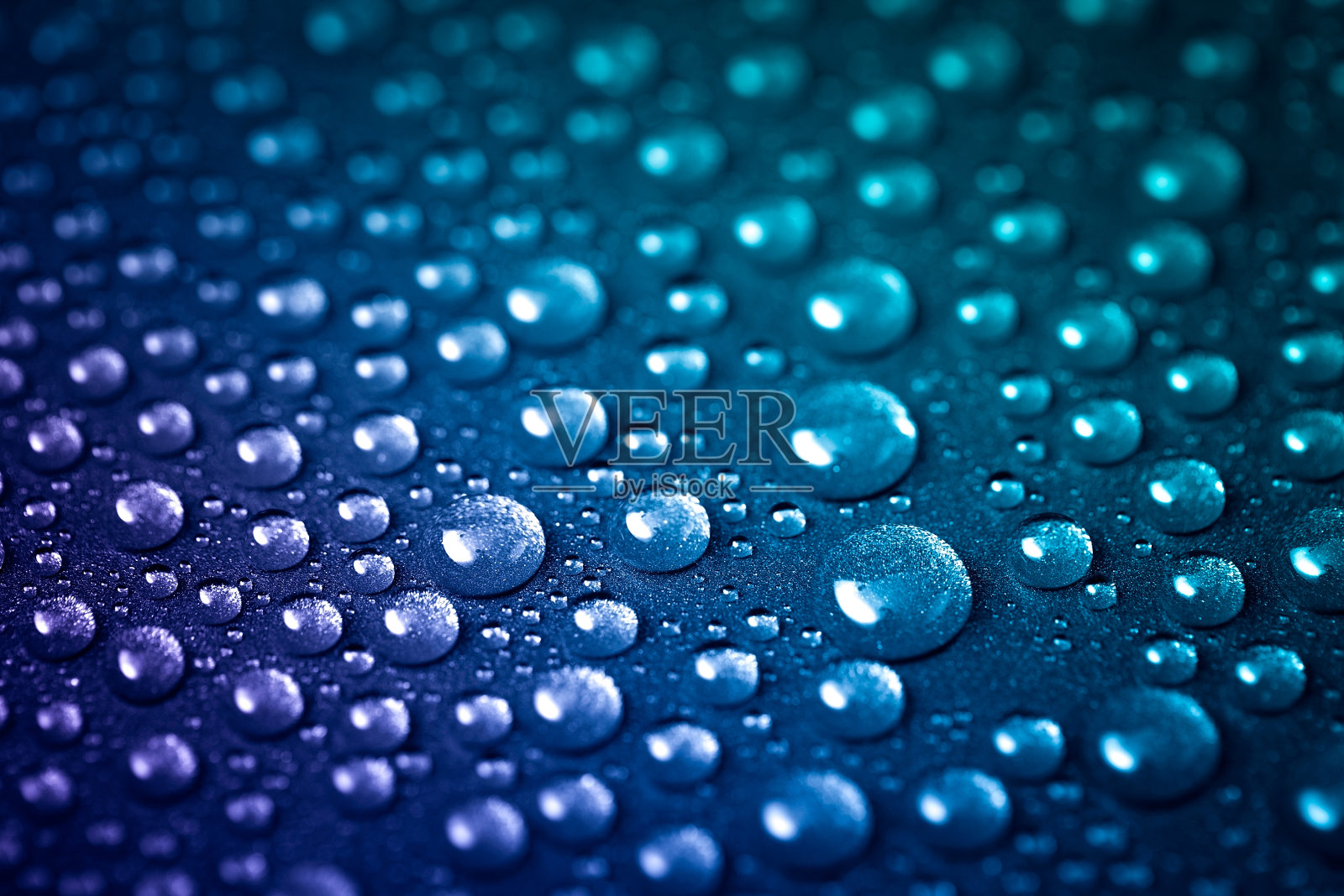 许多水滴溅落在闪亮的金属纹理上。蓝紫色的背景颜色照片摄影图片