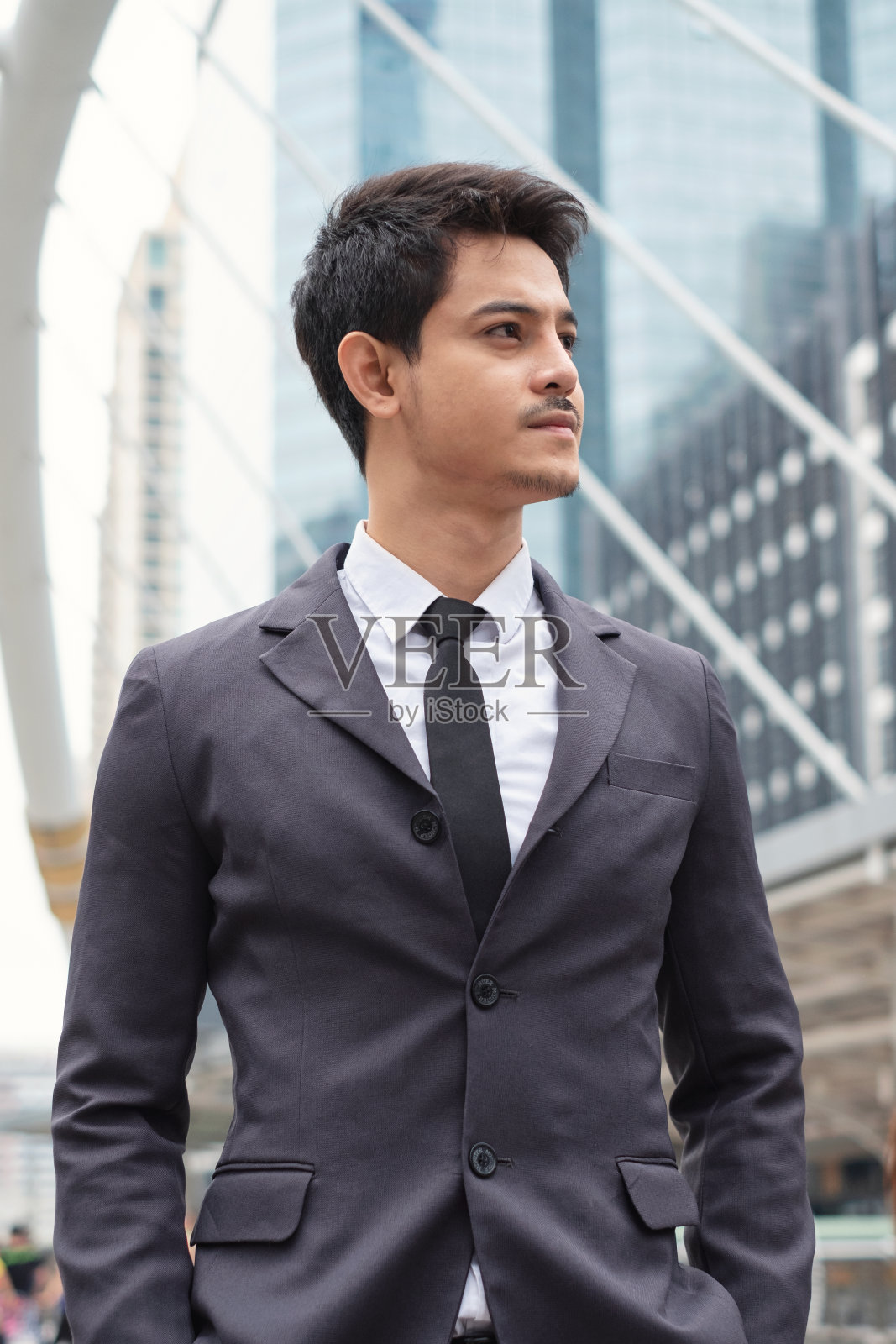 年轻的亚洲商人自信地站在城市的领导地位照片摄影图片