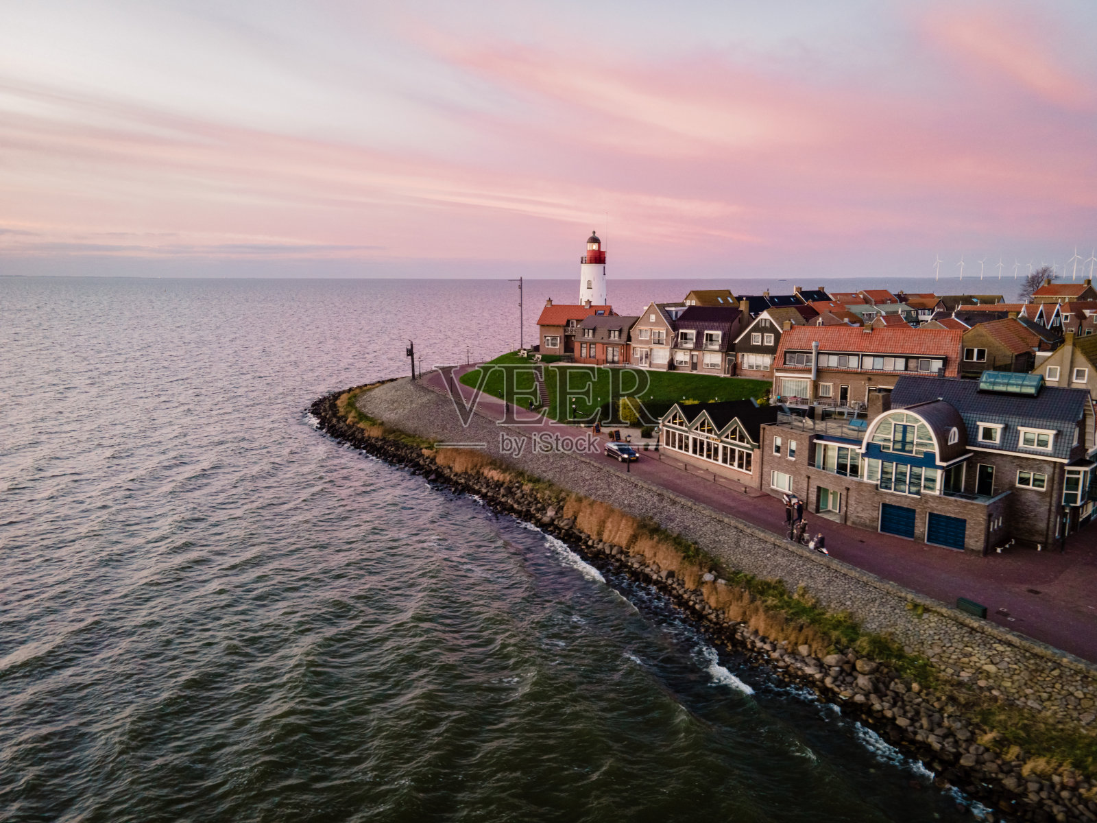 乌尔克灯塔和日落时的老港口，乌尔克是荷兰弗莱弗兰地区伊泽米尔湖边的一个小村庄照片摄影图片