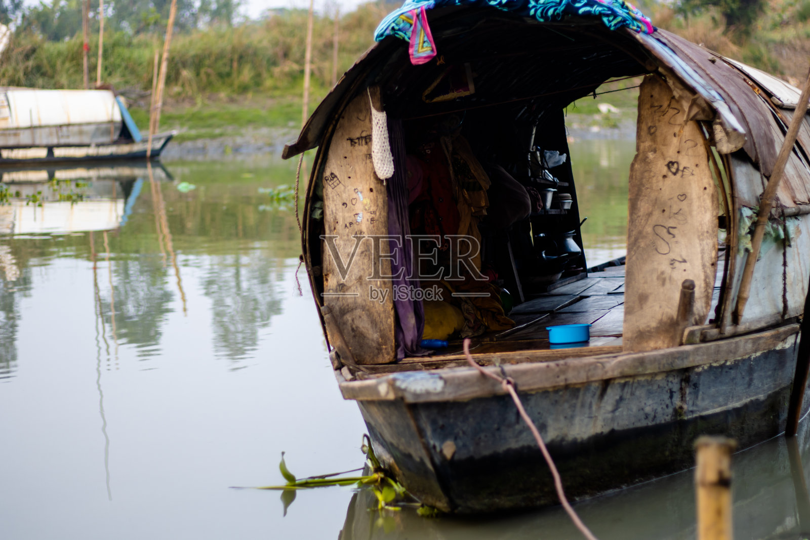 孟加拉国一条小河的岸边停着一艘家庭生活小船照片摄影图片