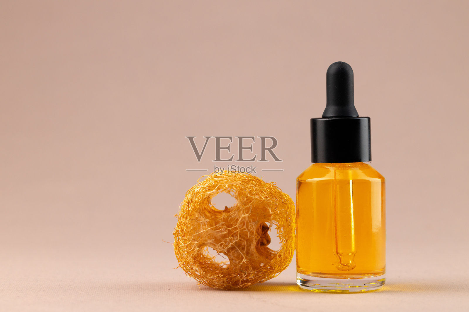 米色背景上配有吸管的美容油瓶照片摄影图片
