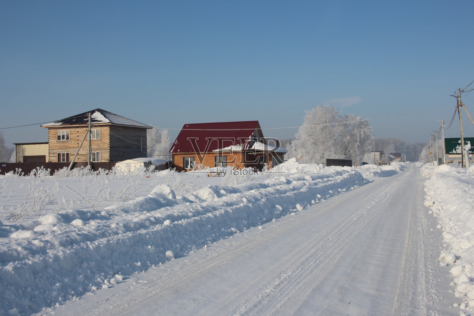 冬天的西伯利亚，雪白的路在雪堆里，美丽的房子在雾凇村照片摄影图片