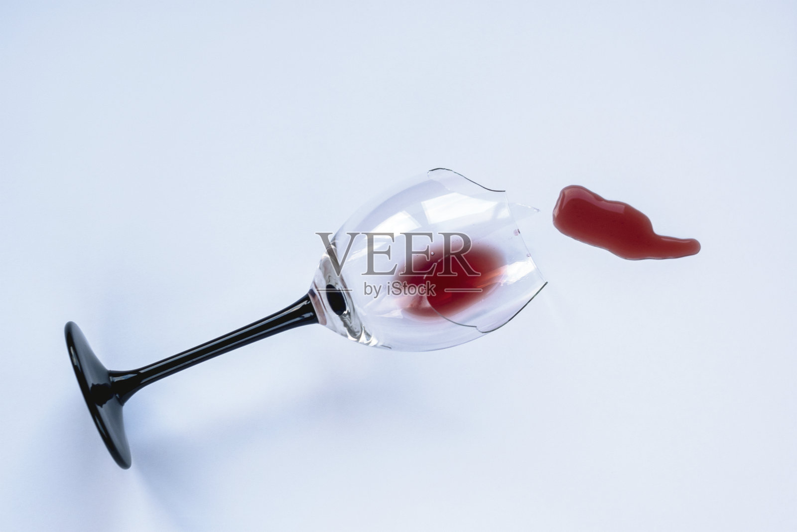 白色背景上洒着红酒的碎酒杯照片摄影图片