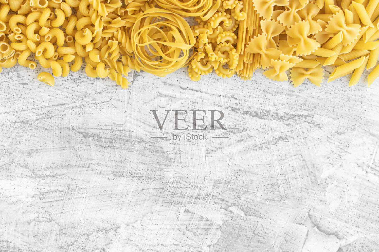 各种各样的意大利面，意大利面A Riso，耳塞普格列西，土豆丸子和法法尔在白色的石头背景与平lay。意大利菜的概念和菜单设计照片摄影图片