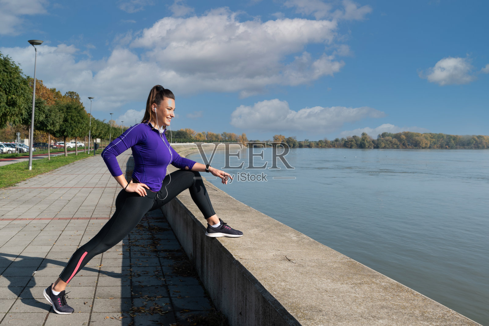 年轻活跃的女运动员伸展她的腿部肌肉为户外跑步运动做准备照片摄影图片