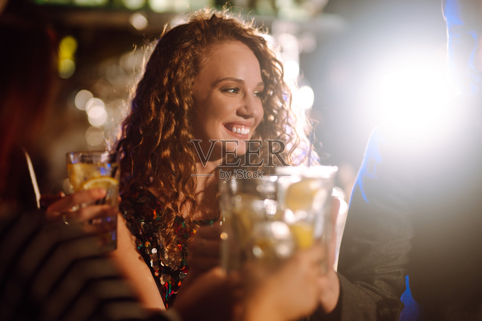 年轻女子在他的手里拿着一杯酒精Сocktail。派对，庆祝，朋友，单身派对，生日，冬季假期概念。照片摄影图片