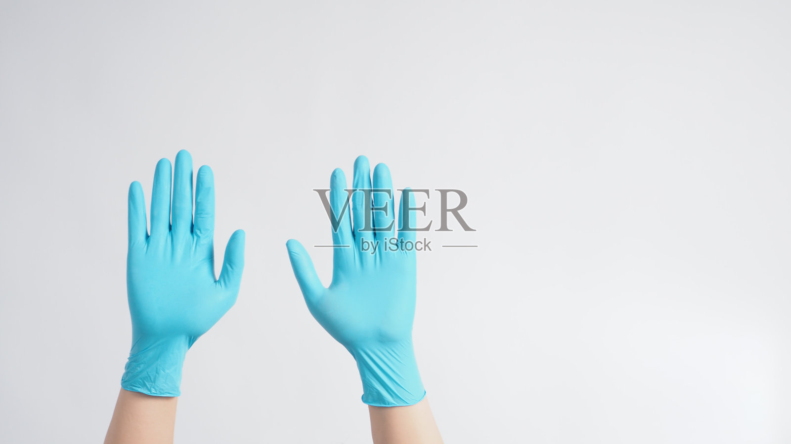 双手与蓝色乳胶手套在白色背景照片摄影图片