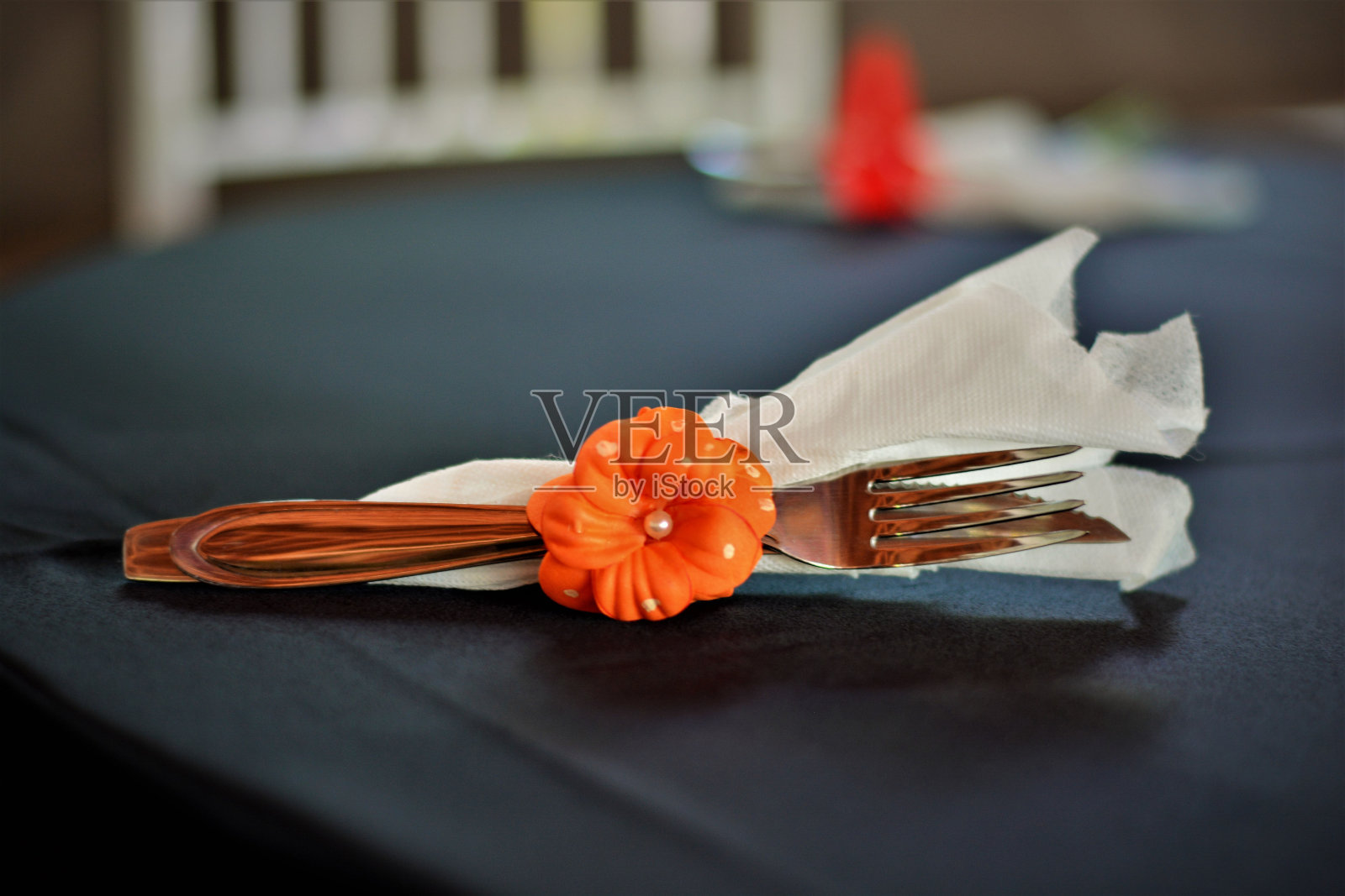 用橘花和餐巾装饰的刀叉照片摄影图片