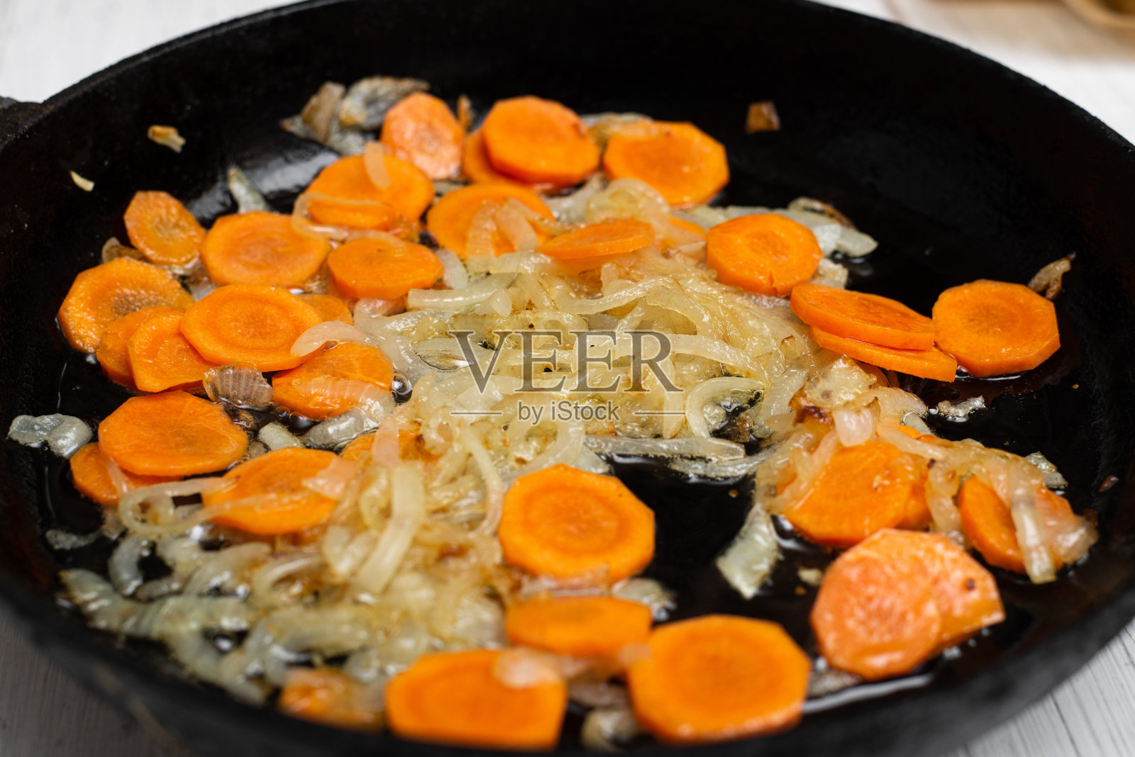 用平底锅煎洋葱和胡萝卜。烤蔬菜，烹饪配料。照片摄影图片