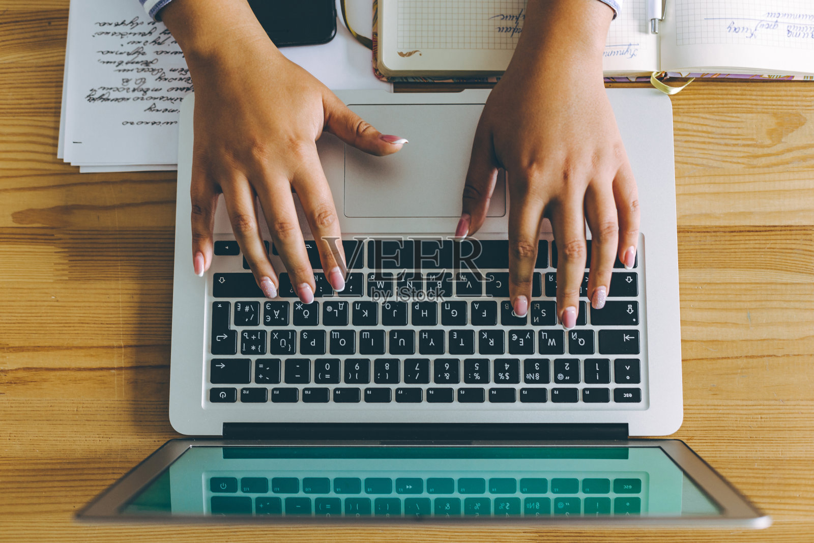 Topview平铺的商务工作场所，笔记本电脑，电话和女人的手打字。照片摄影图片