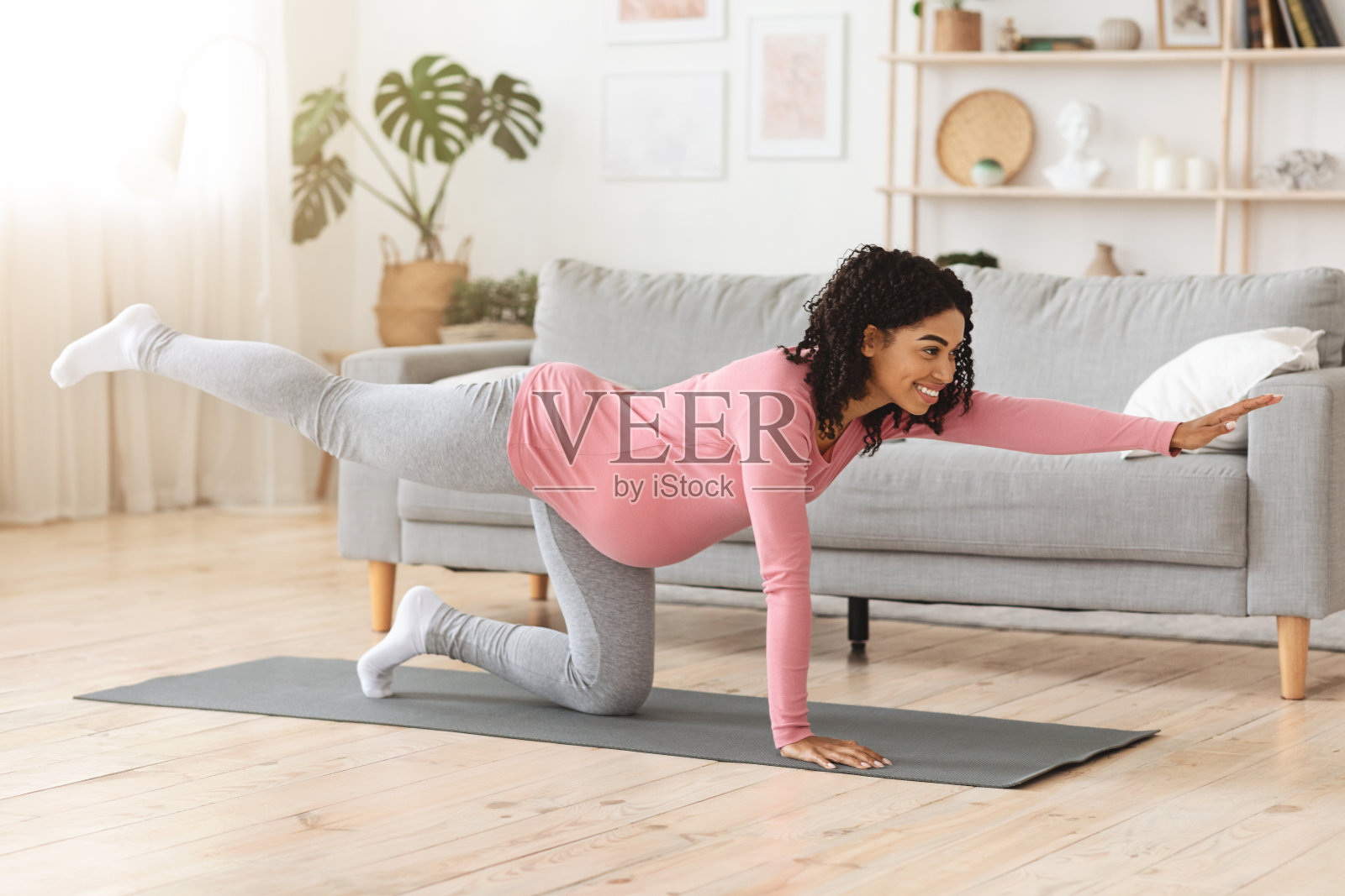 快乐的怀孕黑人妇女伸展她美丽的身体照片摄影图片