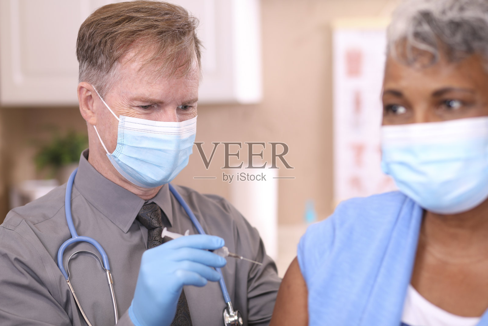 COVID-19:医生和老年人，非洲裔患者，疫苗，口罩。照片摄影图片