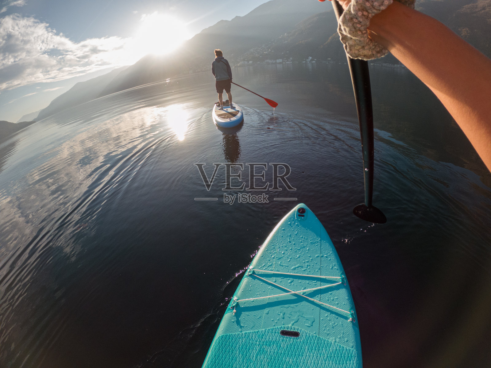 第一人称的观点，一个女人在一个站立桨板上划水照片摄影图片