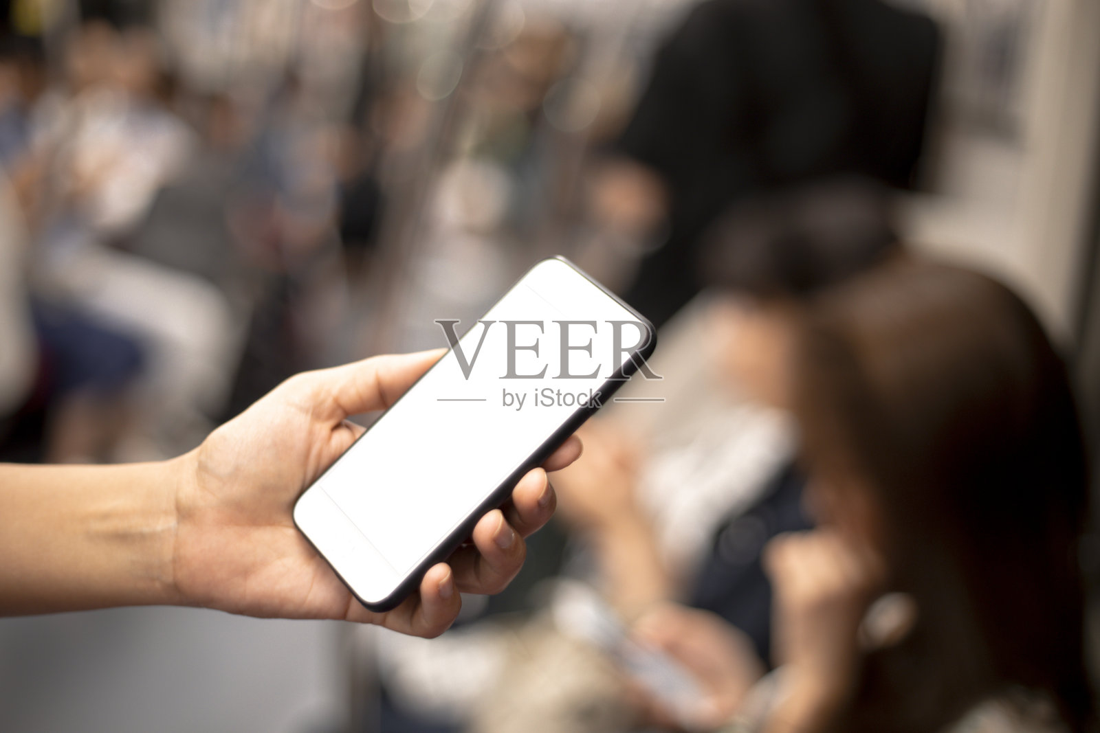 在地铁里看手机的女人照片摄影图片