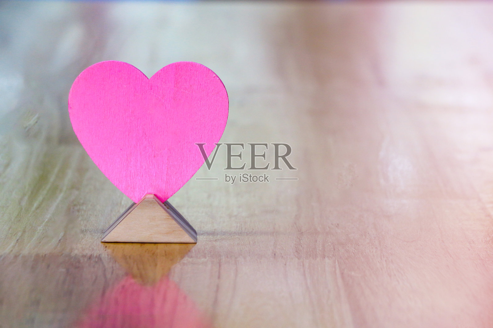 粉色的木心放在木桌上，复制空间，情人节的创意。照片摄影图片