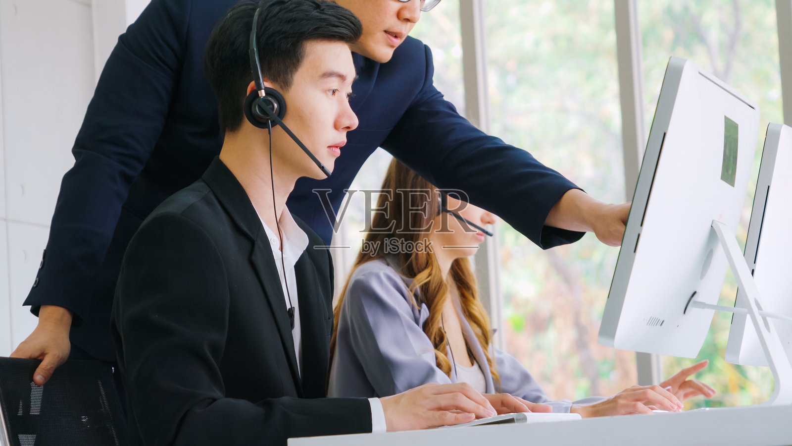 商务人员戴着耳机在办公室工作照片摄影图片