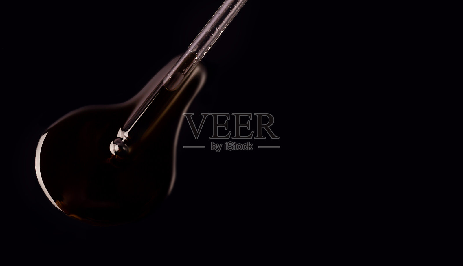 带油的移液管在黑色背景上照片摄影图片