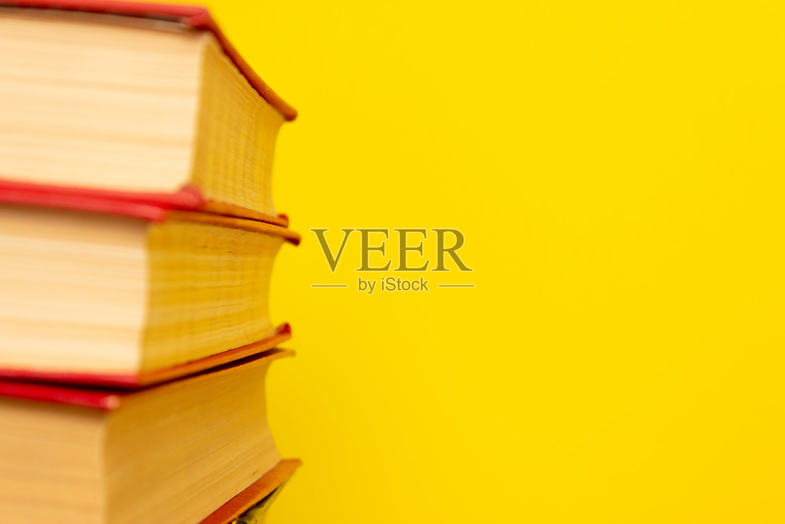 书架的一边，明亮的黄色背景，自由的文字空间。阅读,学习,学校。照片摄影图片