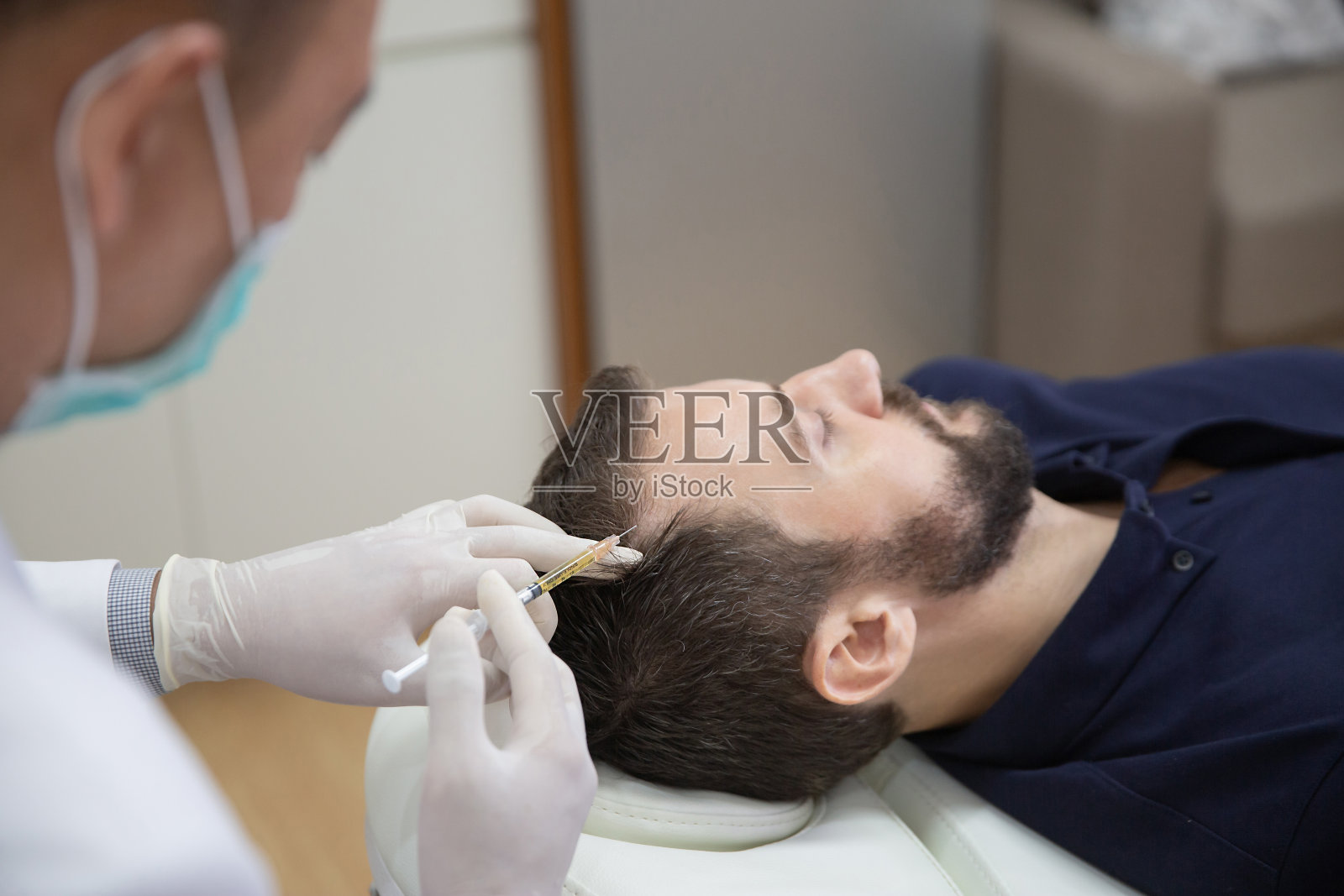 头发中膜疗法或头皮prp:富血小板血浆疗法。美容师在男子头部注射以促进头发生长，防止脱发和秃顶照片摄影图片