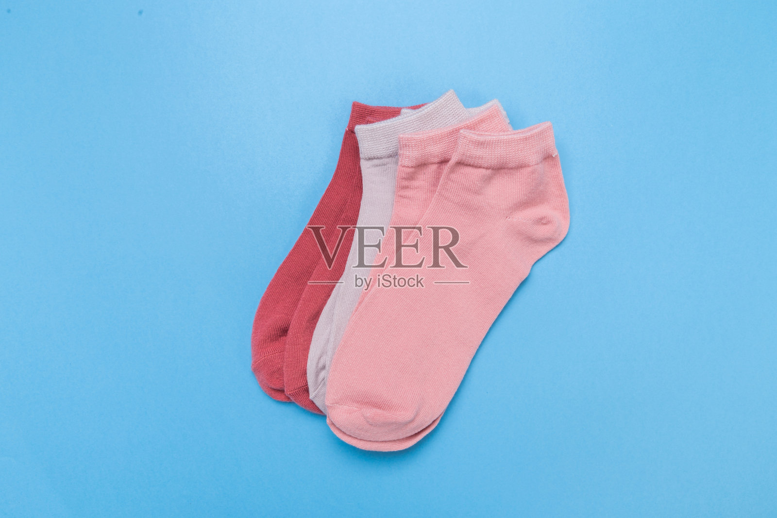 蓝色底色上叠着两双五颜六色的新袜子。前视图。文本。照片摄影图片