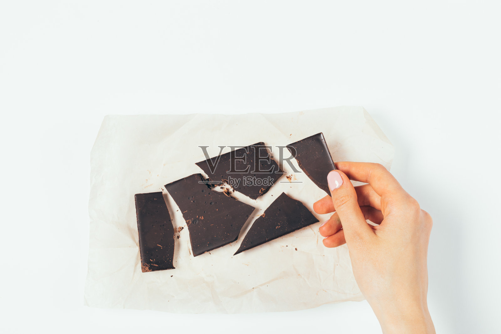 俯视图女人的手拿着一块有机黑巧克力照片摄影图片