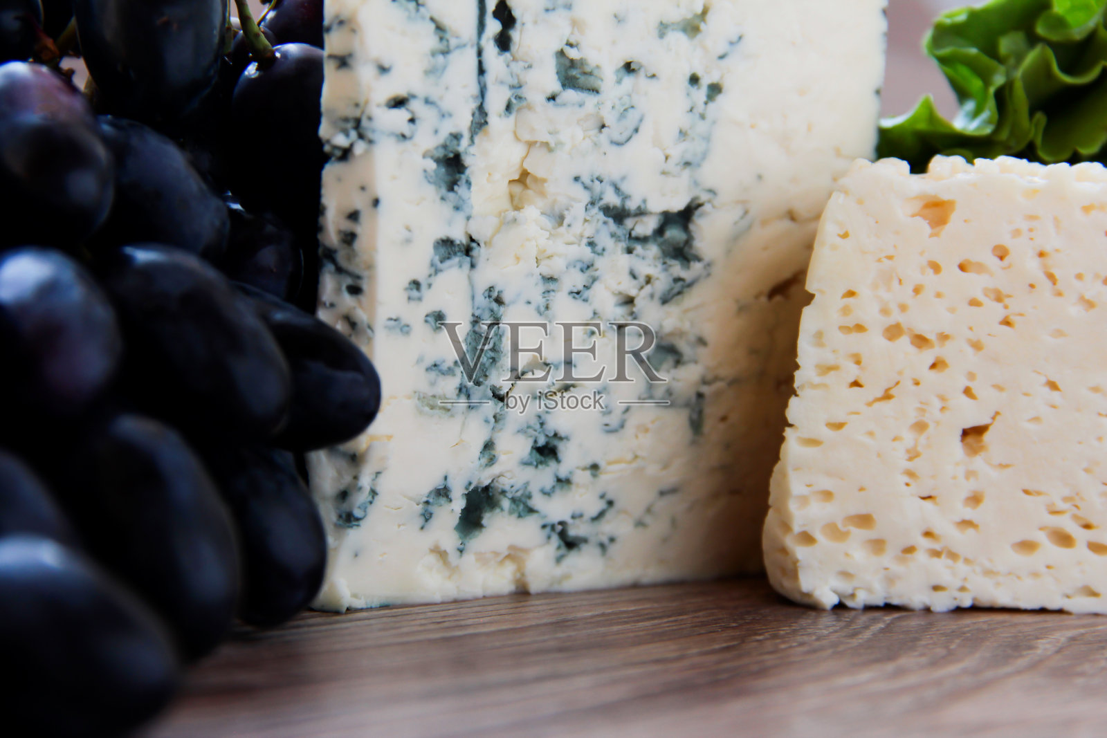 一块蓝奶酪和葡萄。美味的产品。照片摄影图片