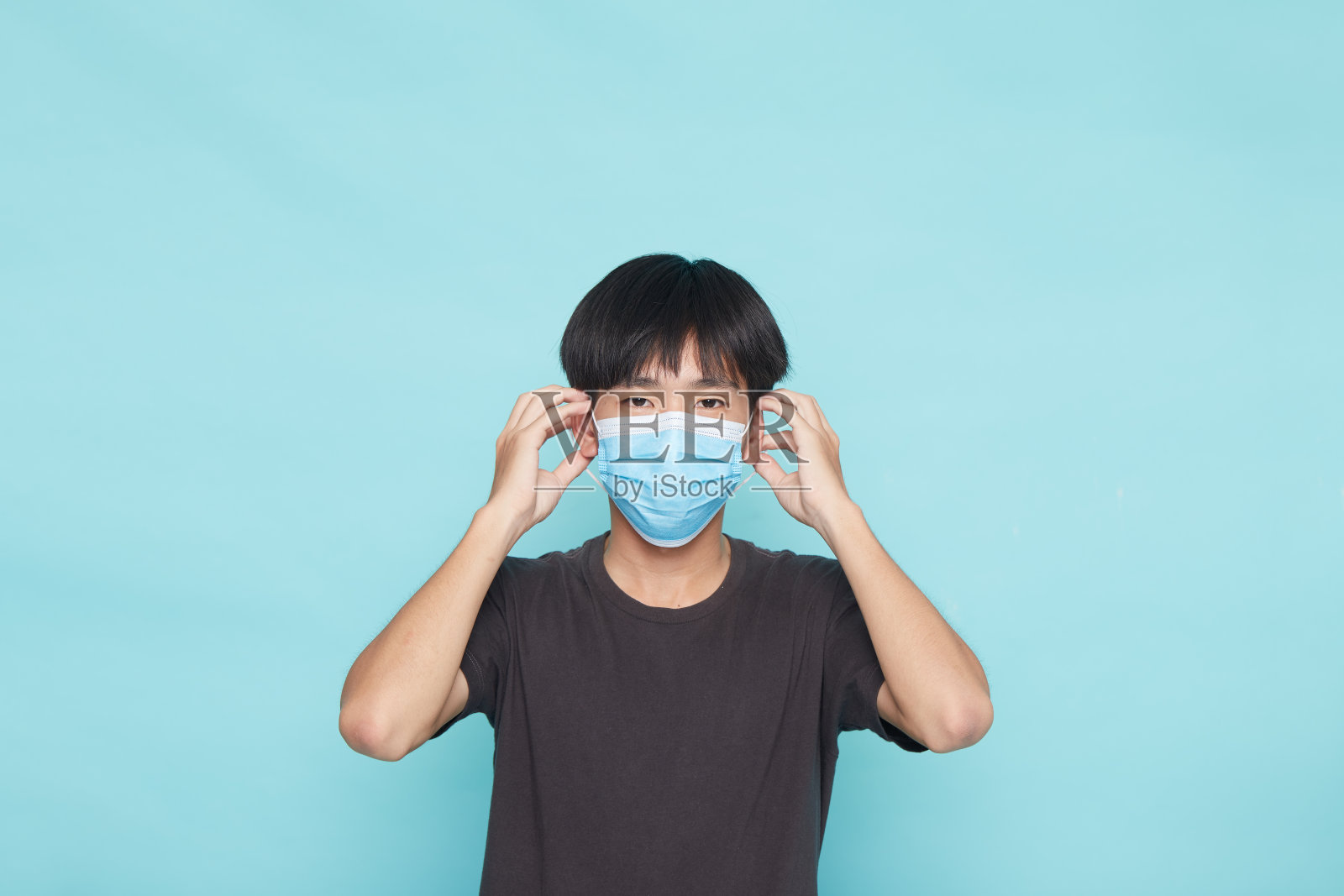 亚洲男子戴口罩2019年感染蓝色隔离背景，概念冠状病毒照片摄影图片