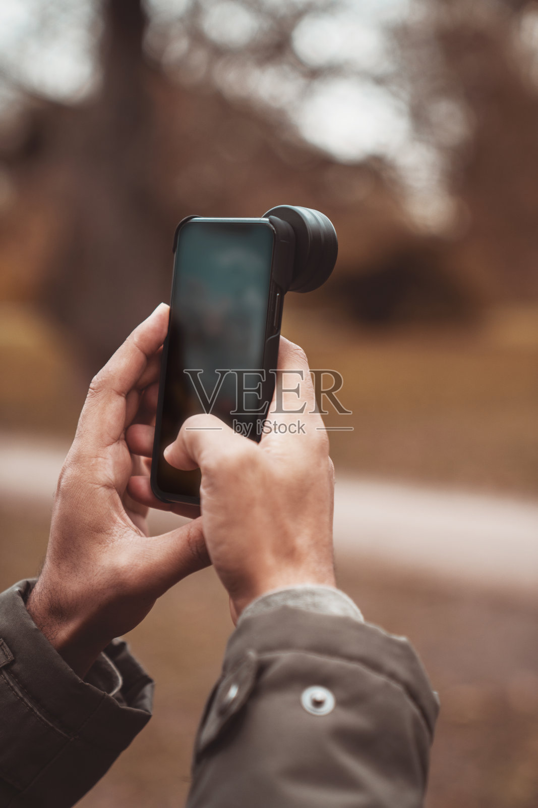 一名男子手持智能手机，展示森林照片照片摄影图片