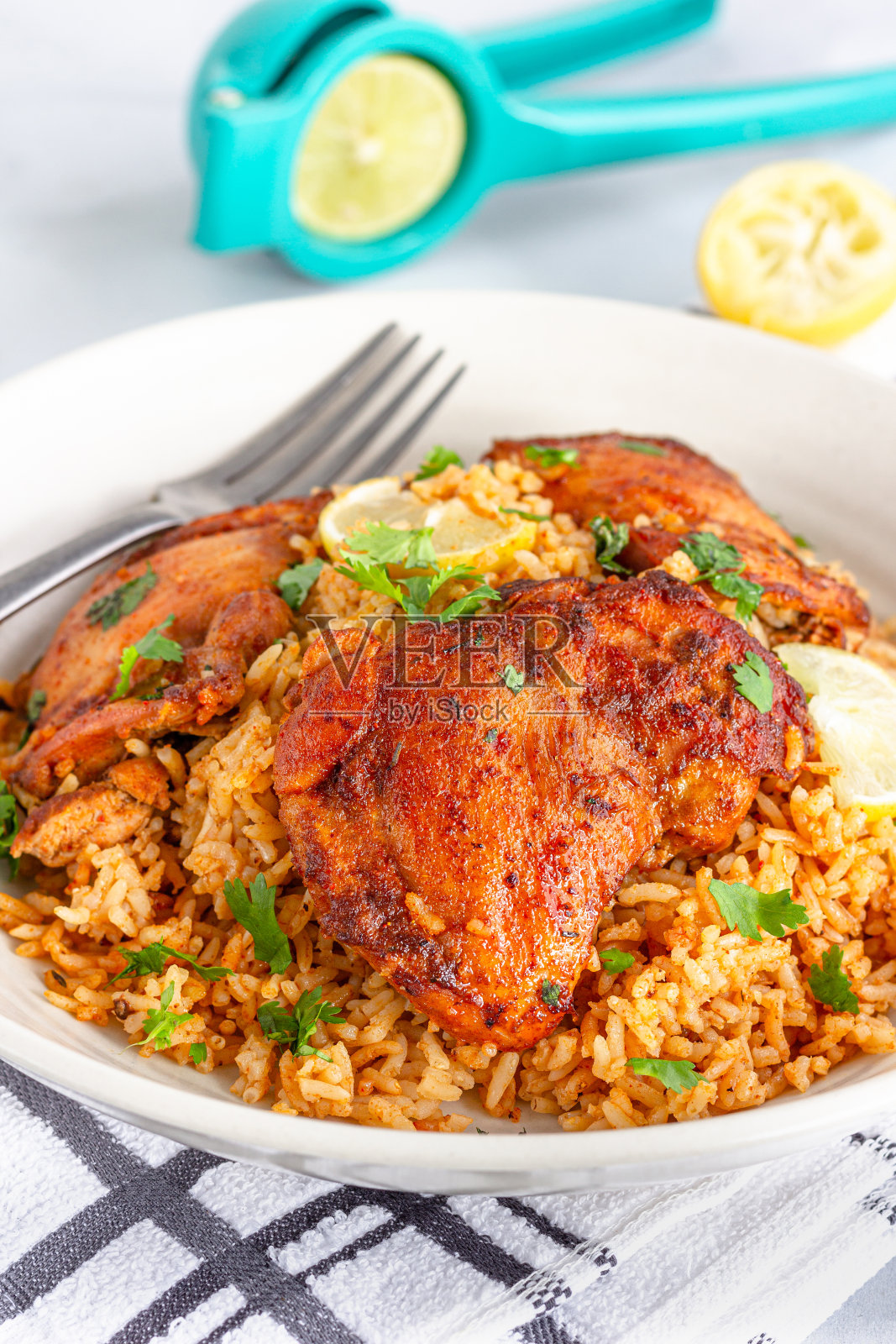 鸡腿放在米饭上，配上香菜和柠檬照片摄影图片