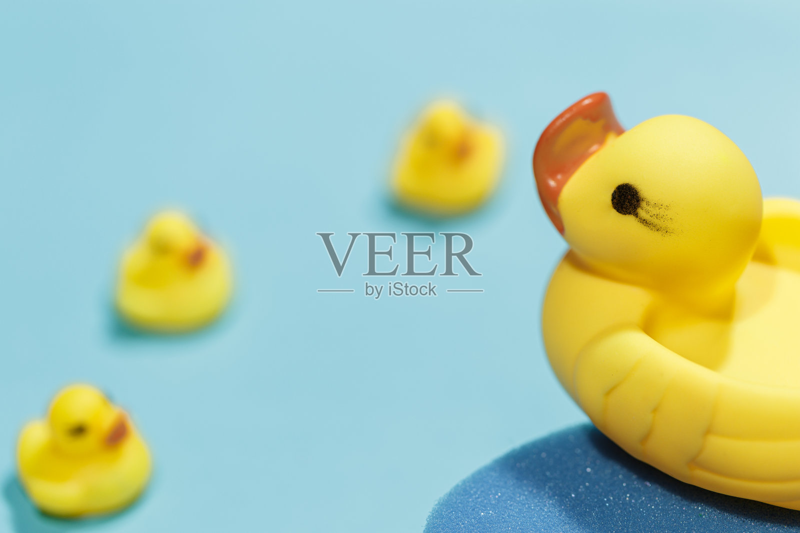 蓝色背景的黄色橡皮鸭子照片摄影图片