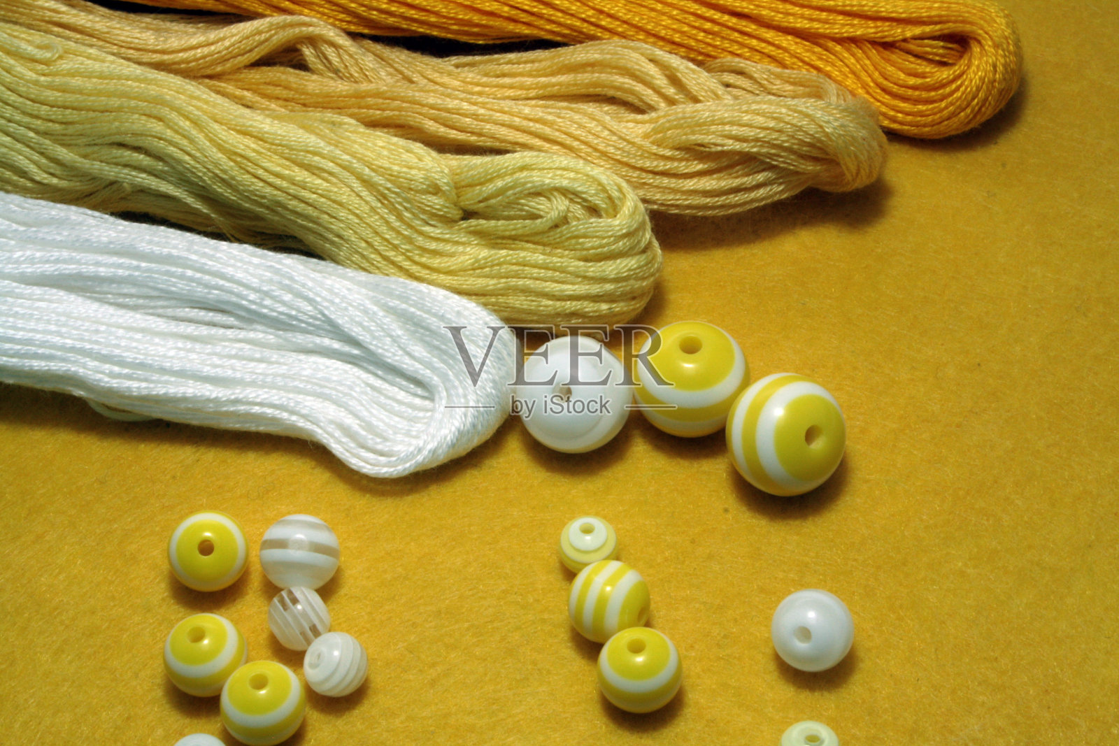 在毛毡背景上刺绣用的珠子和缝纫线照片摄影图片