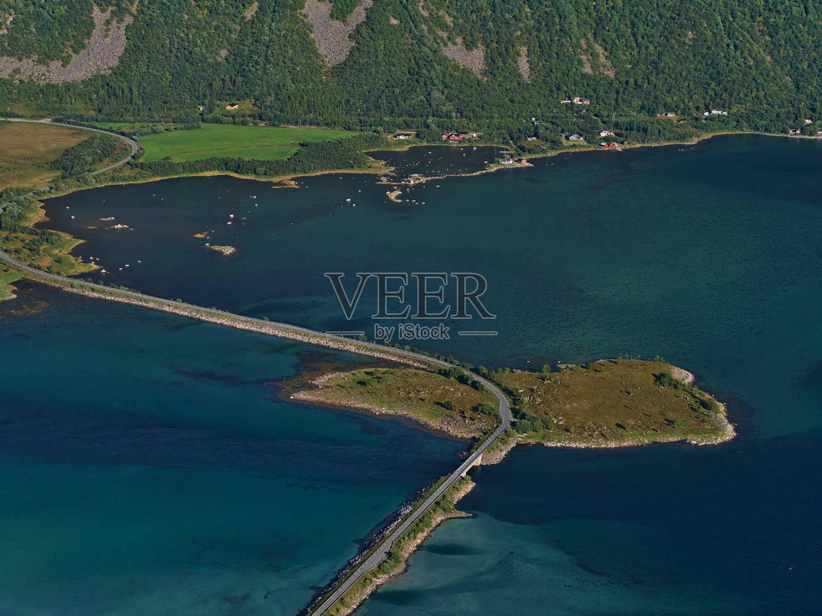 Grunnførfjorden峡湾的美丽鸟瞰图，公路大坝和小岛Storholmen被绿松石和蓝色的浅水包围着Austvågøya海岸。照片摄影图片