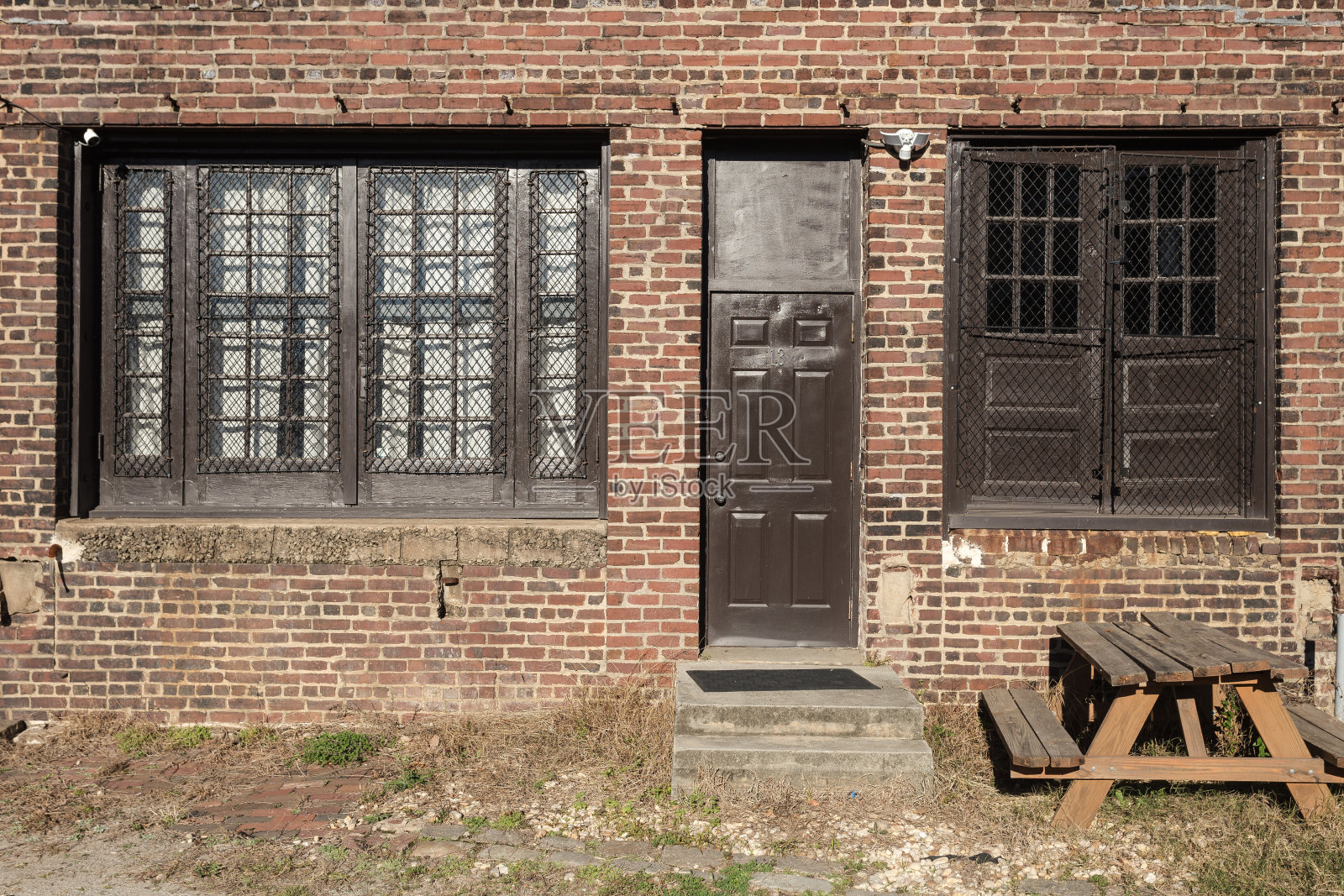 红砖阁楼建筑，在阳光明媚的日子有棕色的门窗照片摄影图片