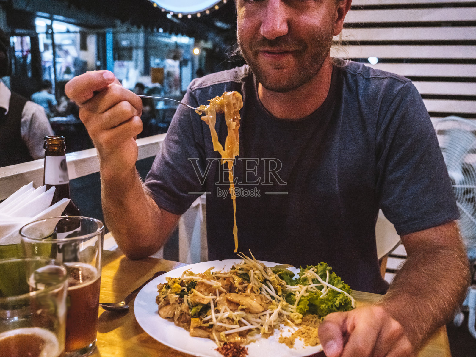 男子在当地餐馆吃泰式炒河粉照片摄影图片