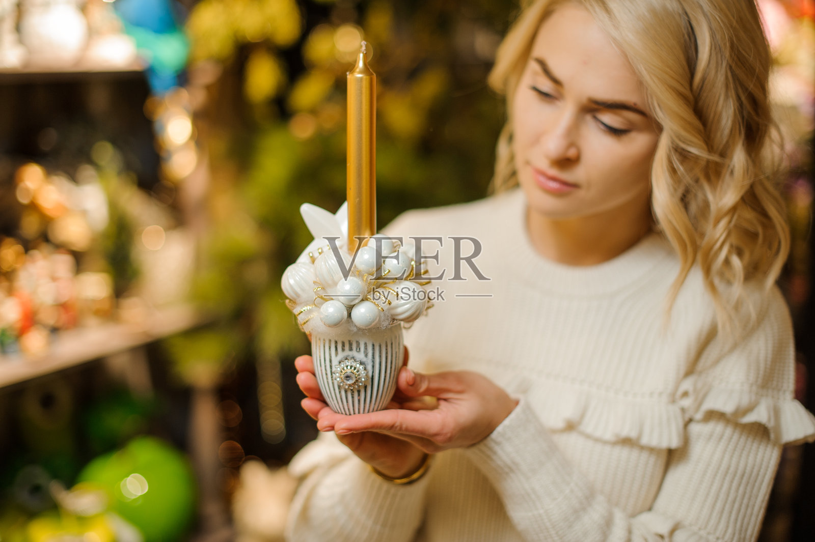 可爱的构图在锅白色圣诞球和金色的蜡烛在女人的手中照片摄影图片