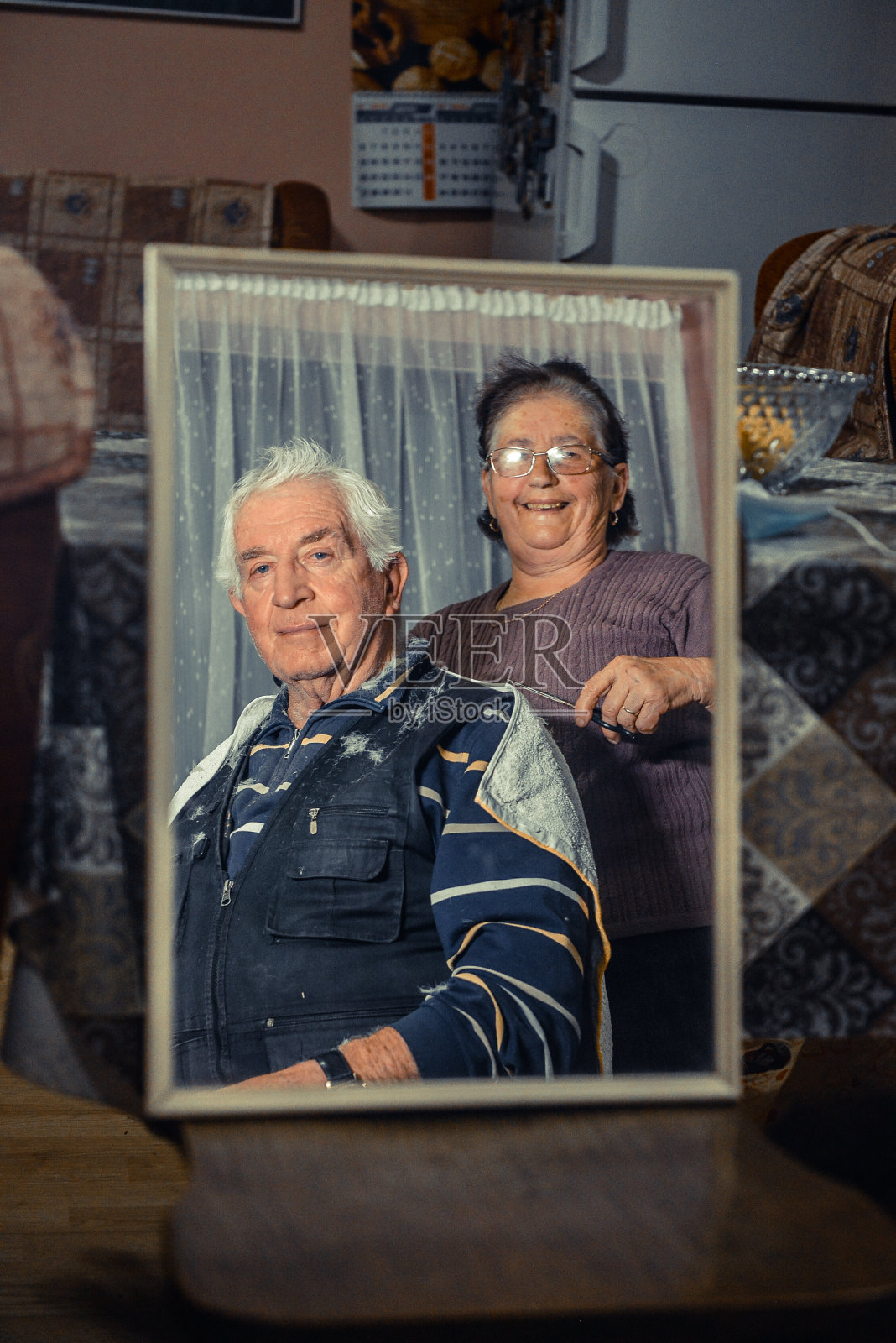 一位资深女士剪了她丈夫的头发-在封锁期间剪的照片摄影图片