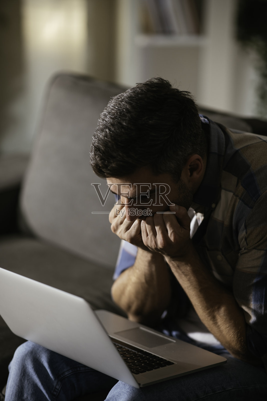 年轻人很惊讶地拿着他笔记本电脑的库存照片照片摄影图片