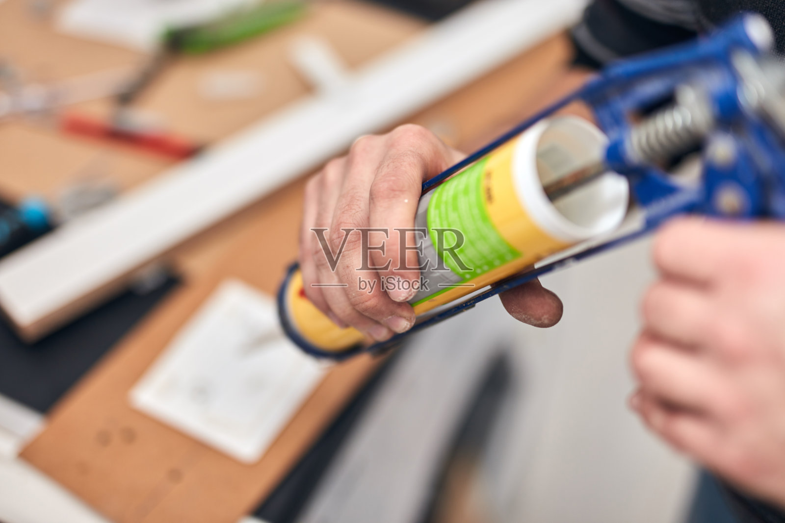 杂务工用硅酮密封胶粘合固定家居用品。照片摄影图片