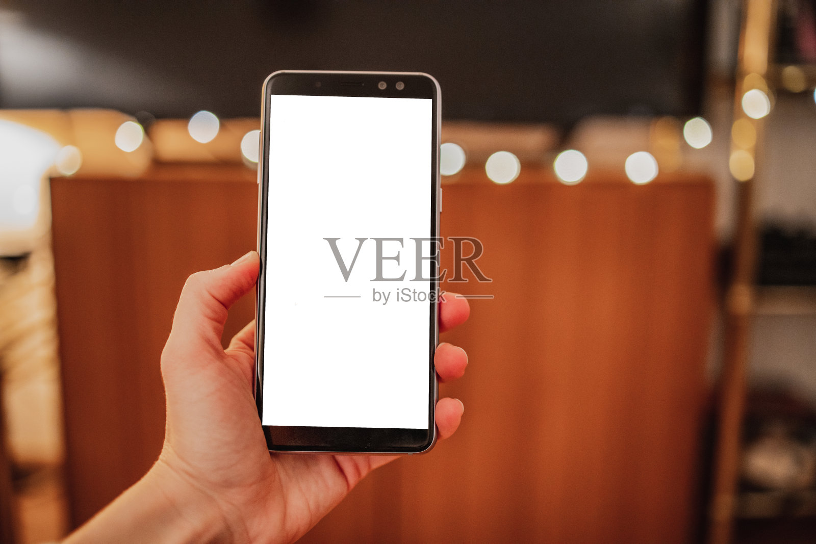 个人视角的手机在家里一个白色空屏幕。观点照片摄影图片