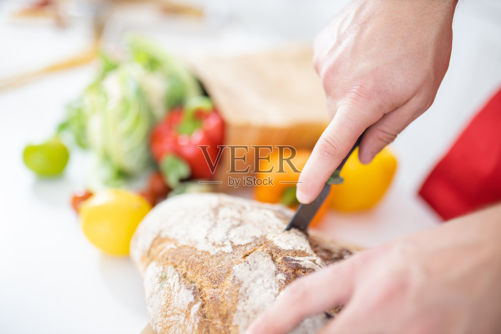 男性用手在砧板上切面包照片摄影图片