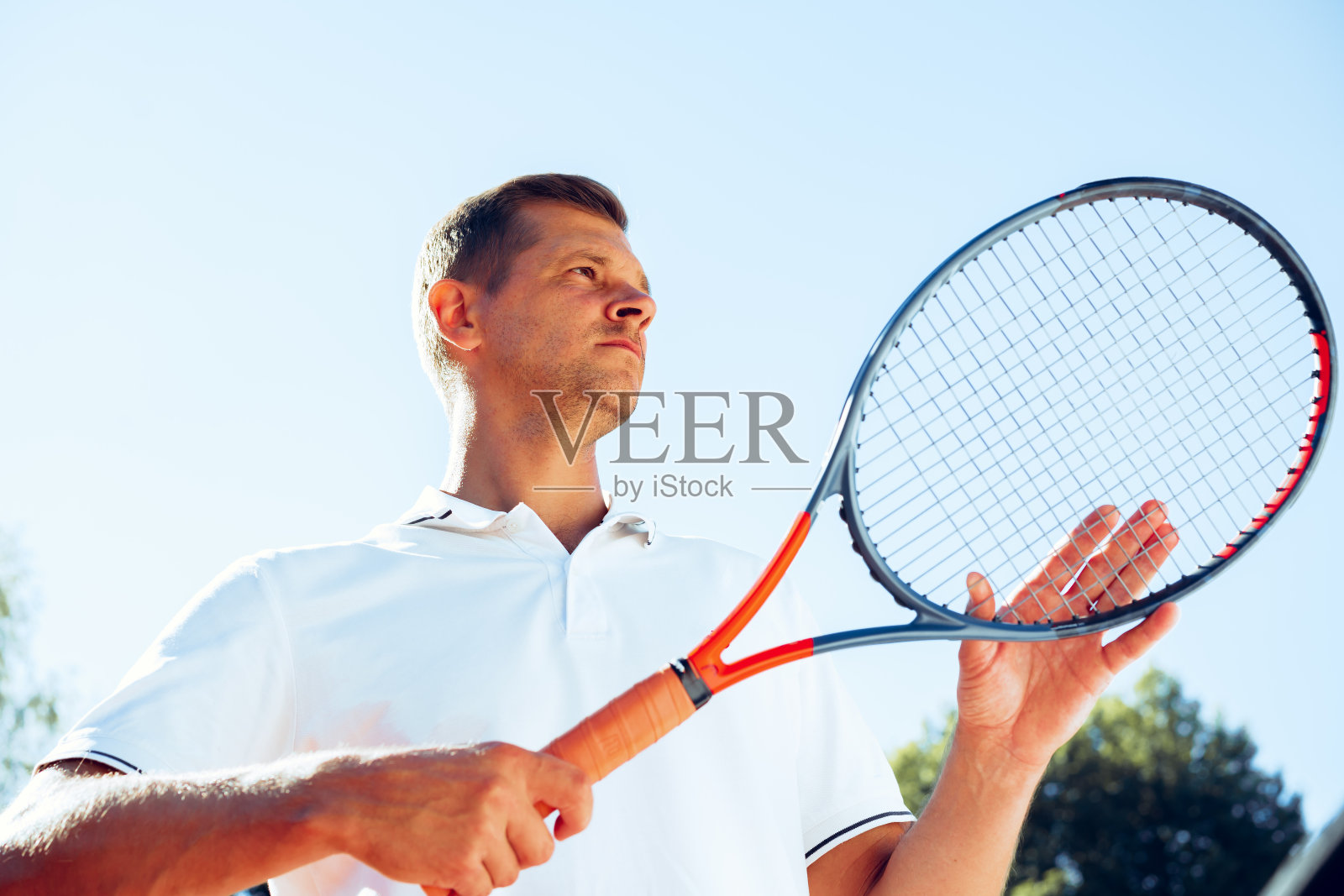 一个年轻的网球运动员检查他的球拍开始一场比赛照片摄影图片