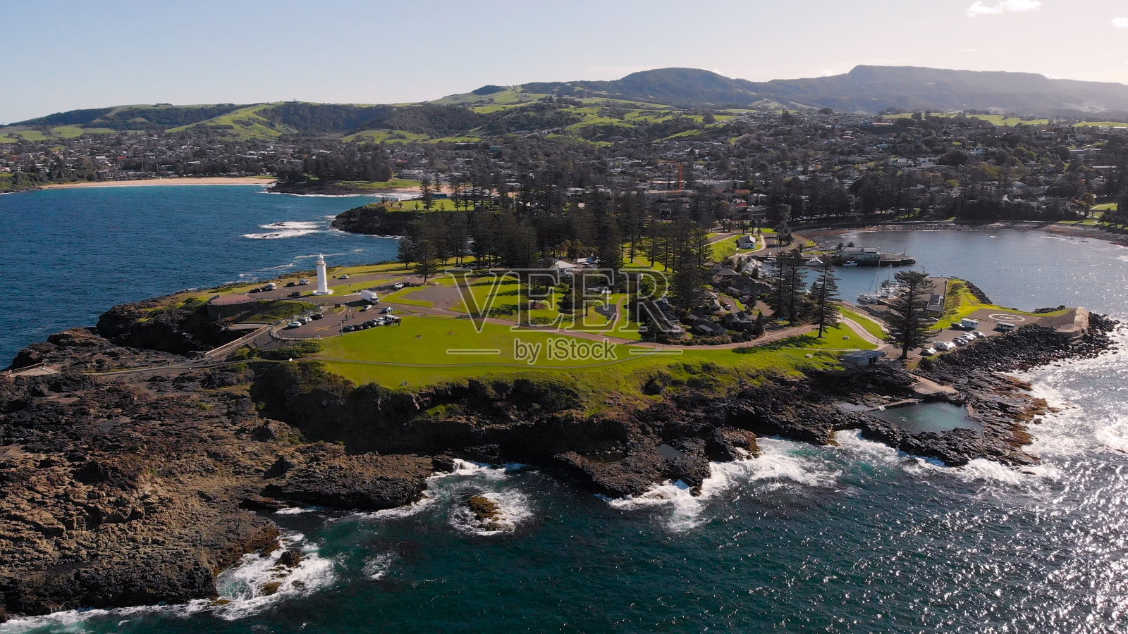 一座白色的灯塔耸立在海上。基亚马是澳大利亚的一个度假小镇。风景如画的岩石岬的鸟瞰图照片摄影图片