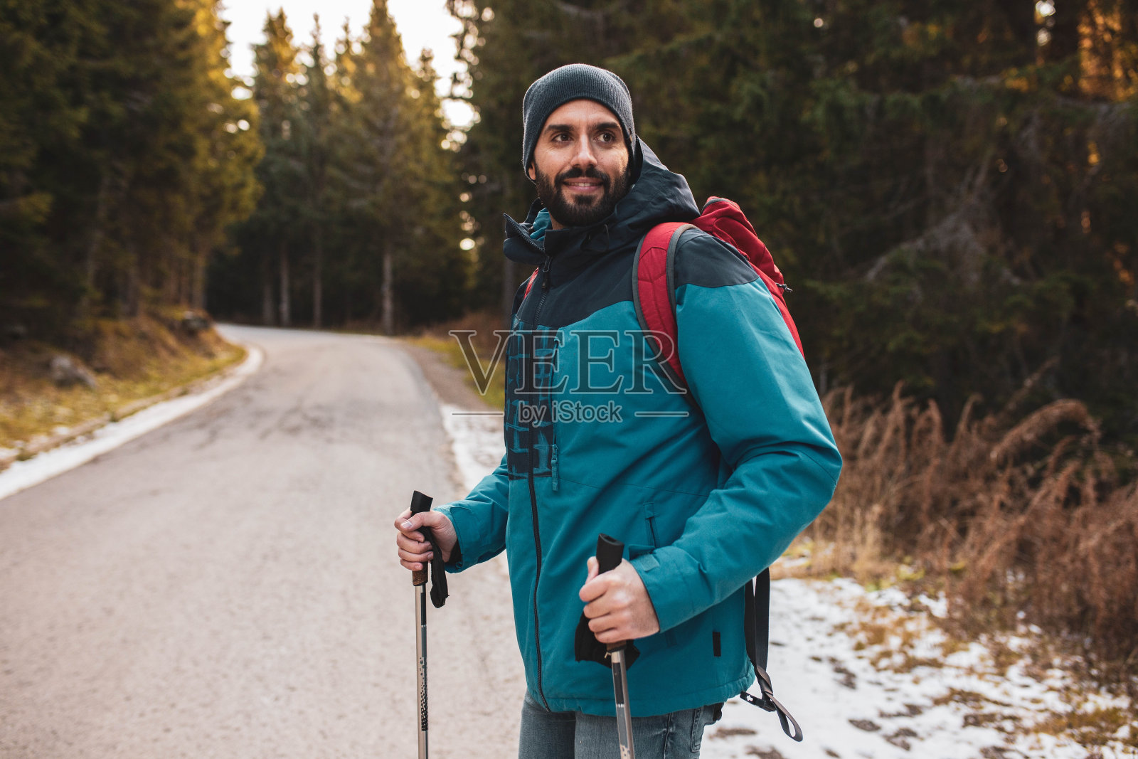 一个英俊的男人在一个寒冷的冬天在一座山上徒步探索森林照片摄影图片